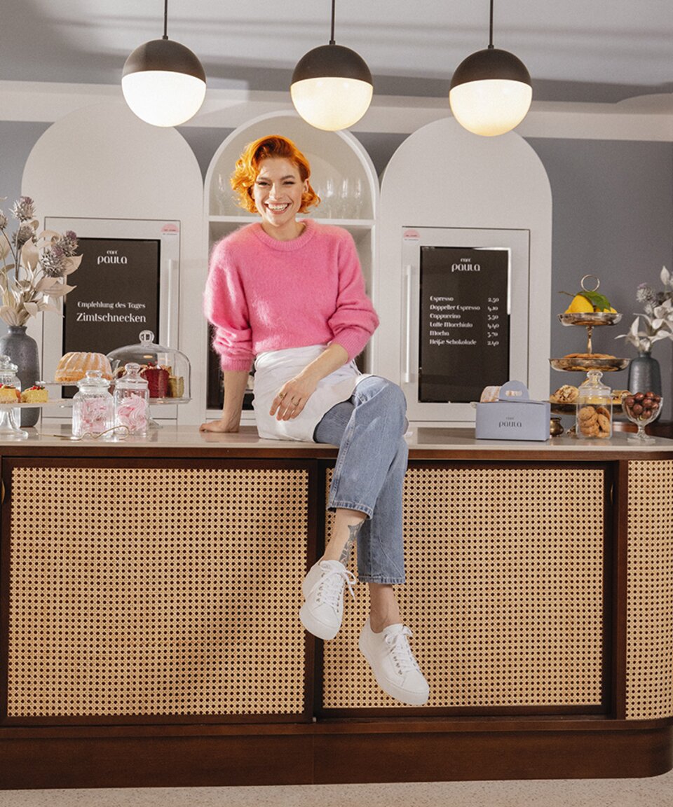 Woman in coffee shop wearing Paul Green sneakers